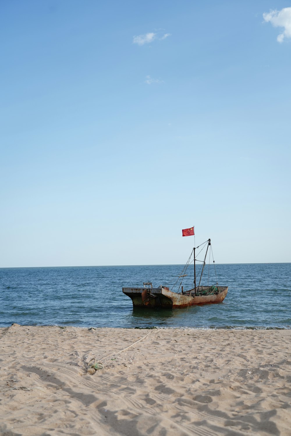 a boat sitting on top of a sandy beach