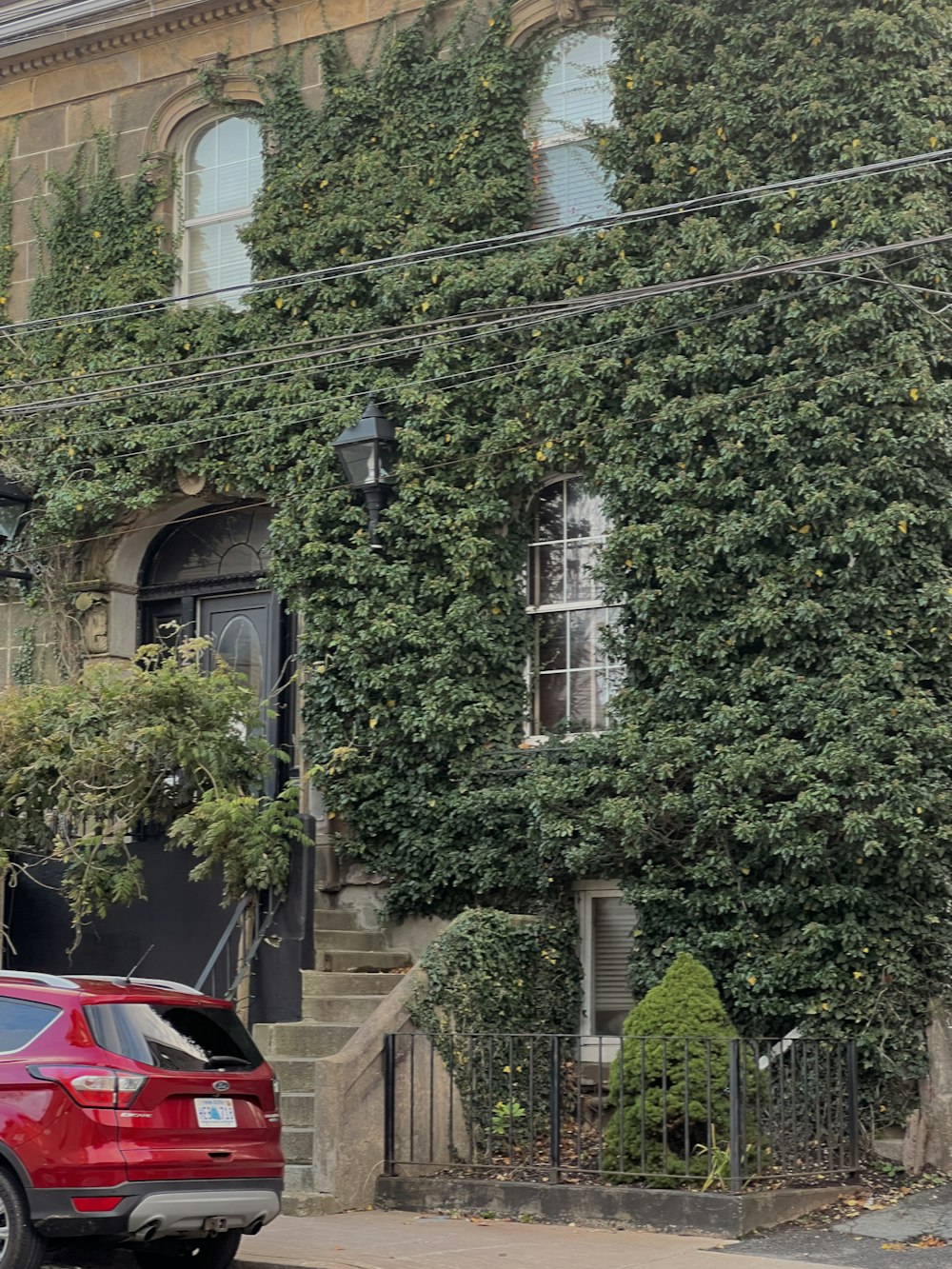 a red car is parked in front of a house