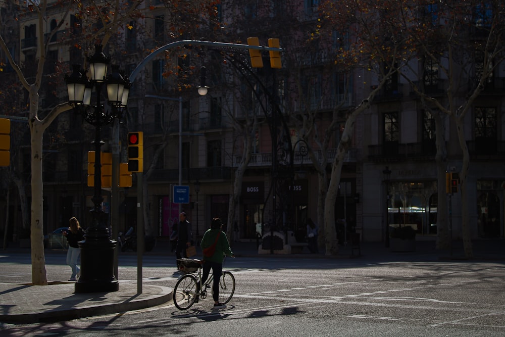 a man riding a bike down a street next to a traffic light