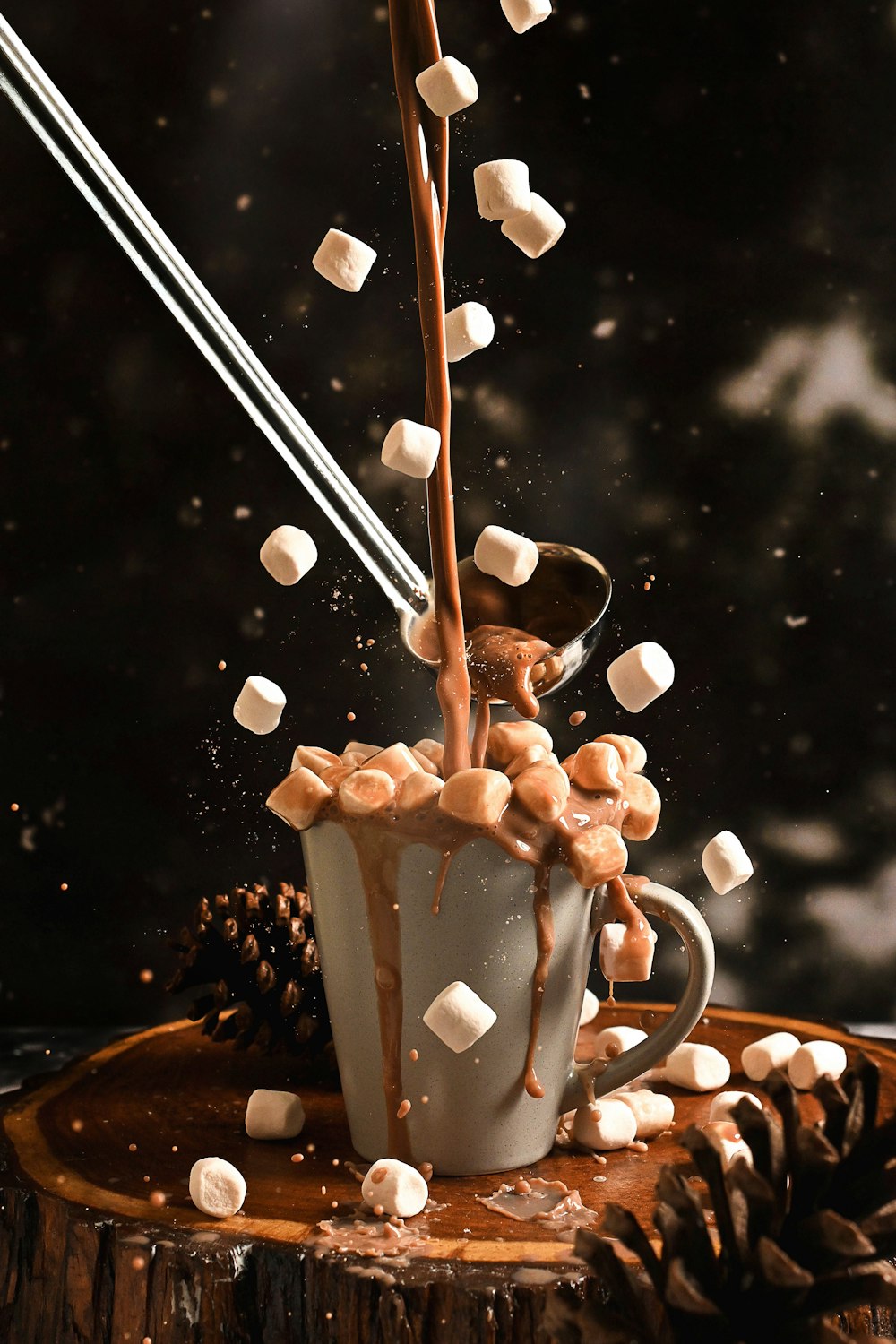 uma xícara de chocolate quente com marshmallows caindo nele