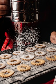 a person is sprinkling sugar on some cookies