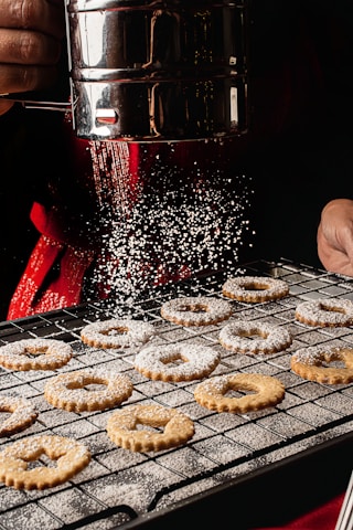 a person is sprinkling sugar on some cookies