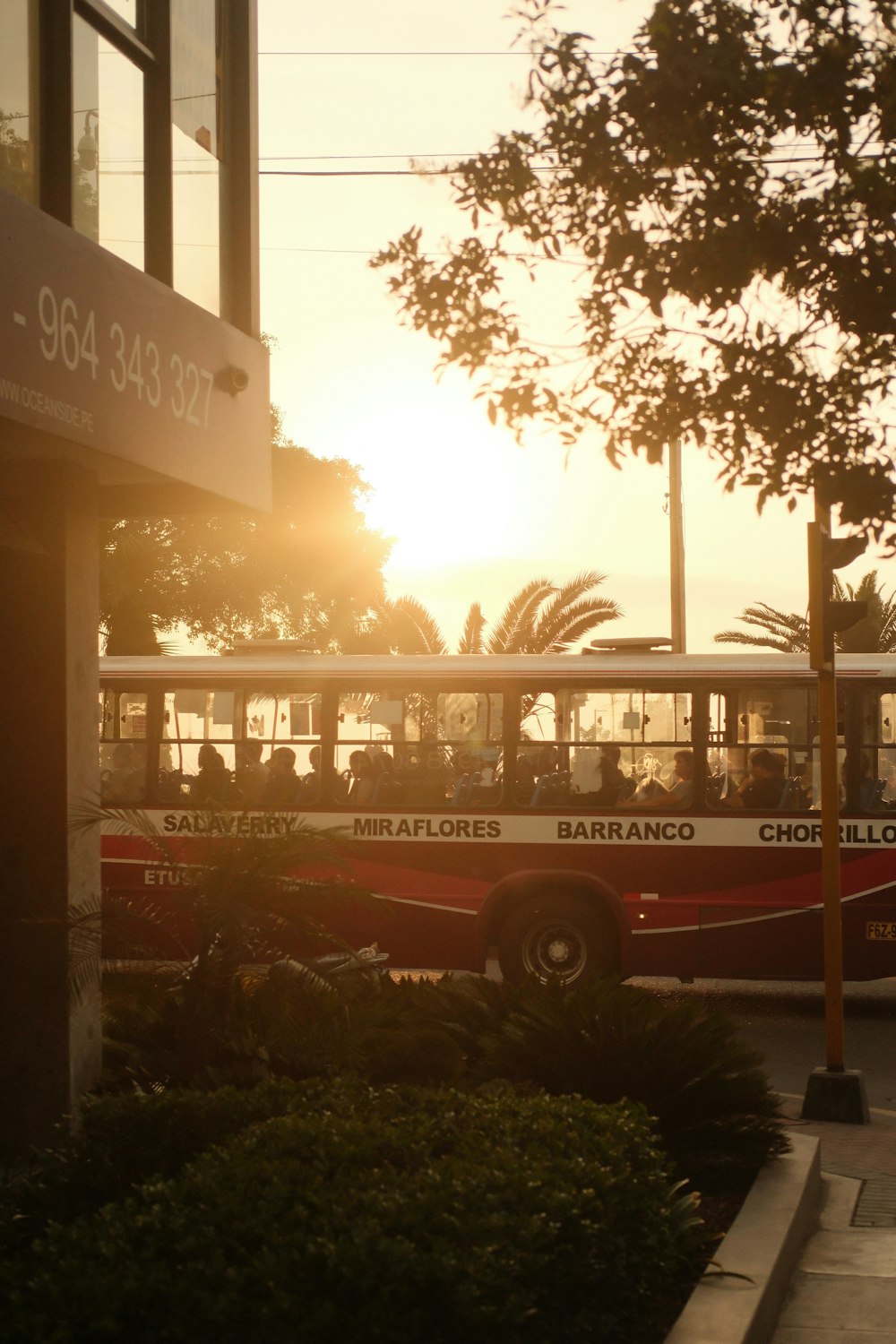 a red and white bus driving down a street