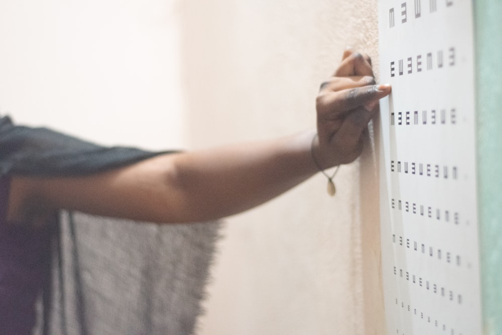 una persona che scrive su un muro con un pennarello