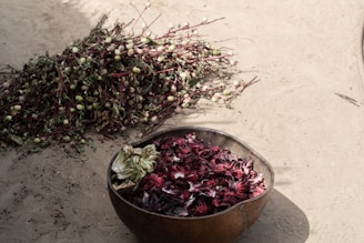 a bucket of dried flowers sitting next to a pile of dried flowers