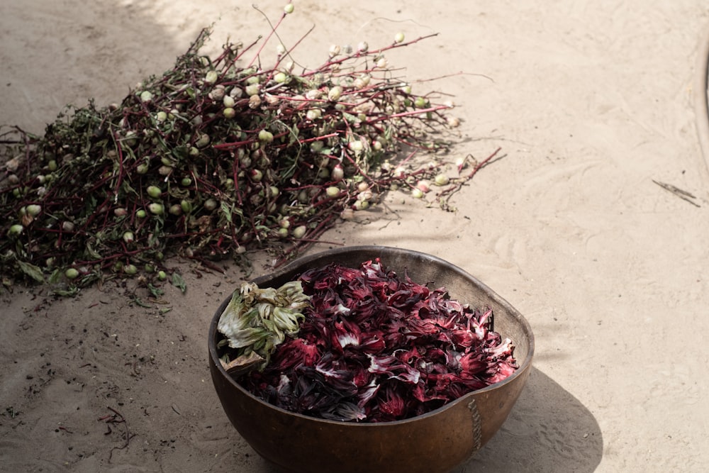 um balde de flores secas sentado ao lado de uma pilha de flores secas