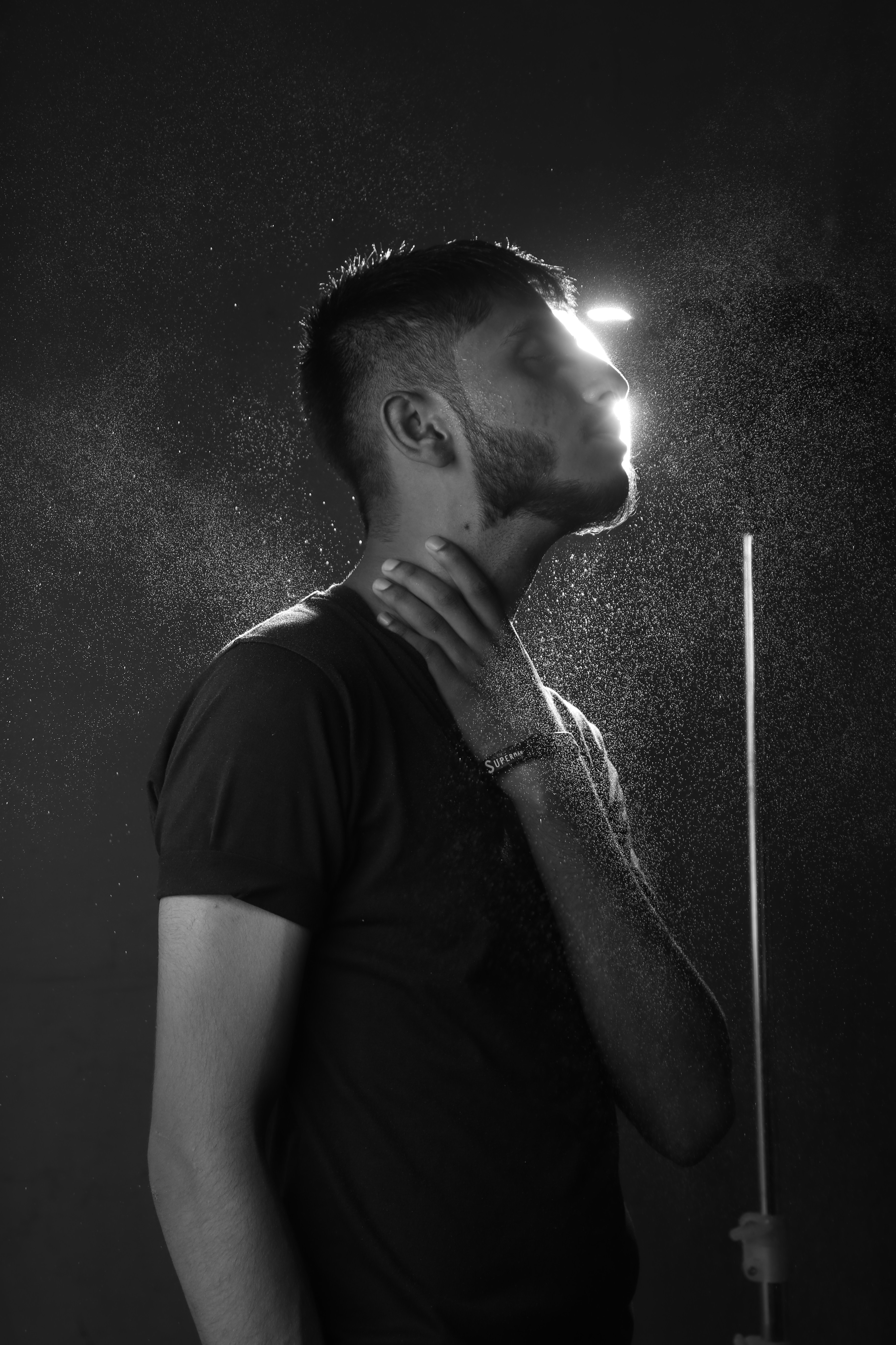 Un hombre de pie bajo una ducha de agua