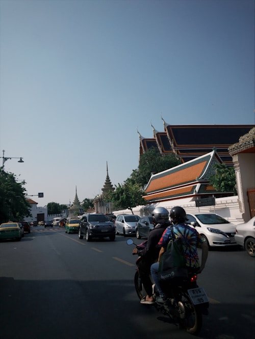 a couple of people riding on the back of a motorcycle