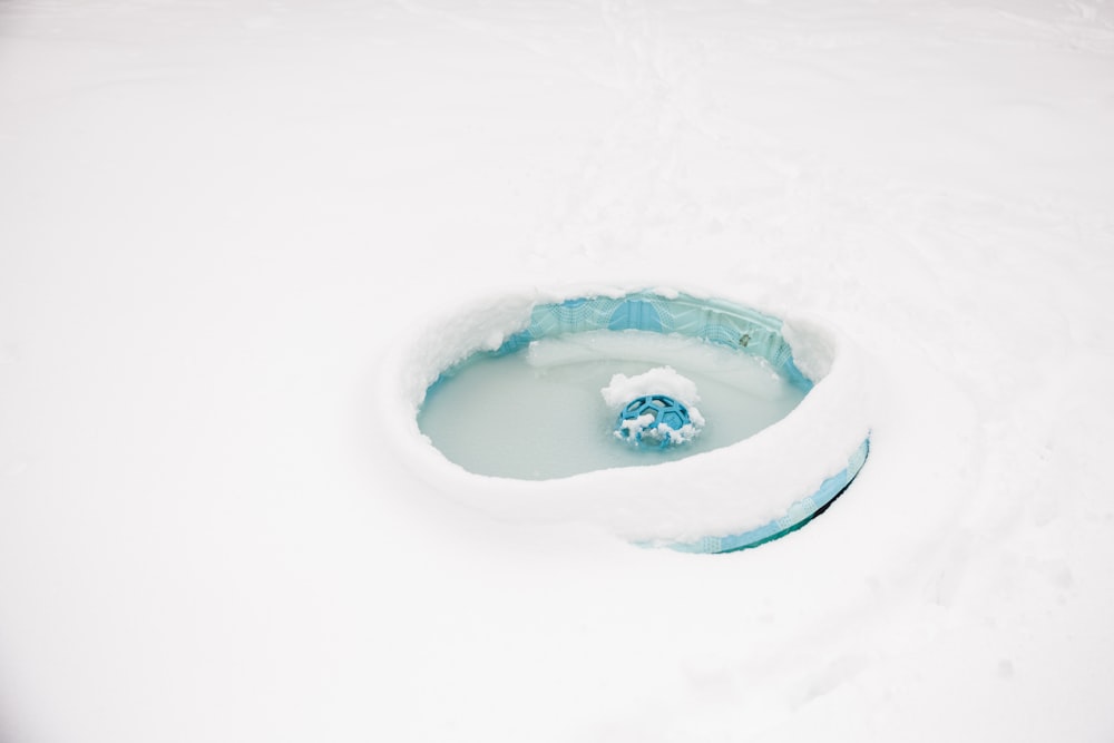 un suelo cubierto de nieve con un objeto azul y blanco en él