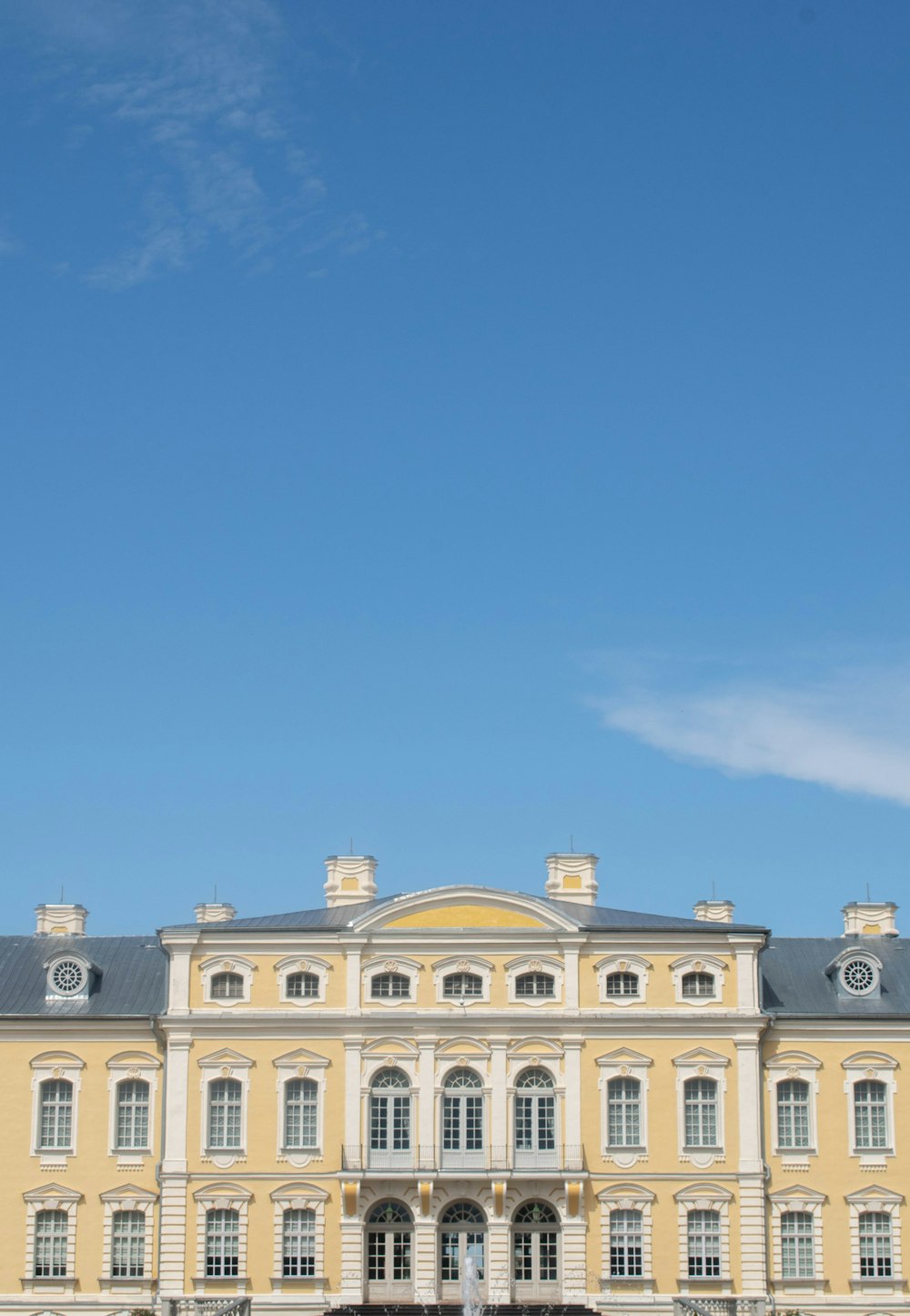 un grand bâtiment avec une fontaine devant