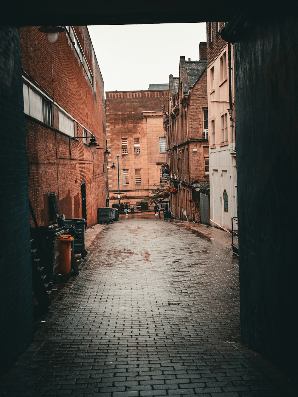 an alley way with a brick walkway between two buildings
