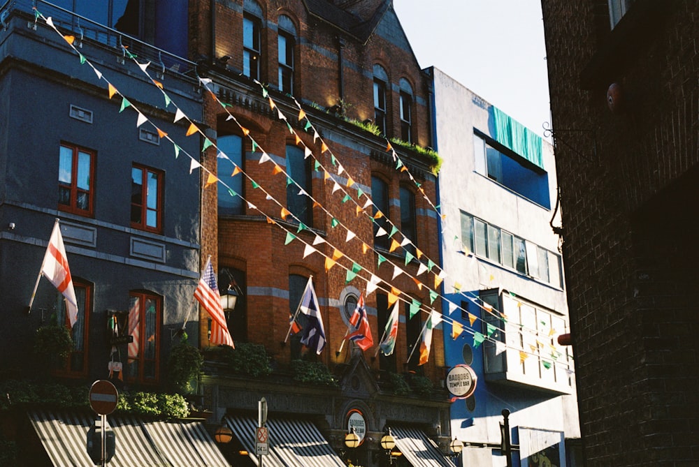 a building with a bunch of flags hanging from it's side