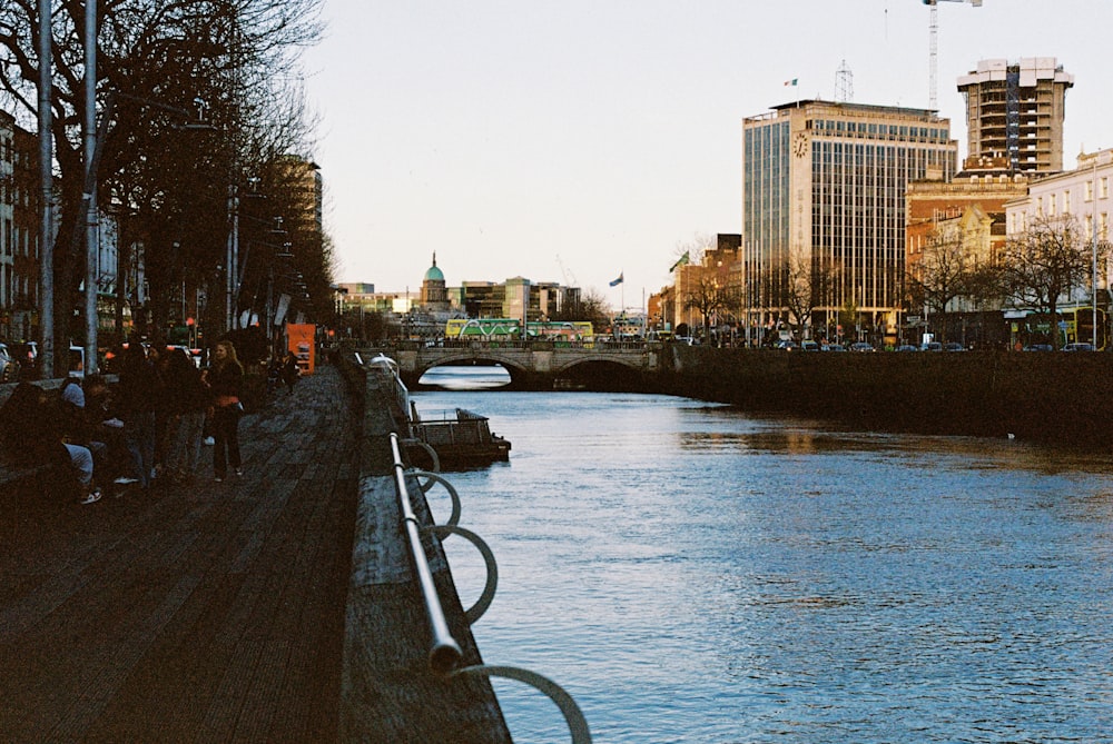 a group of people standing on the side of a river