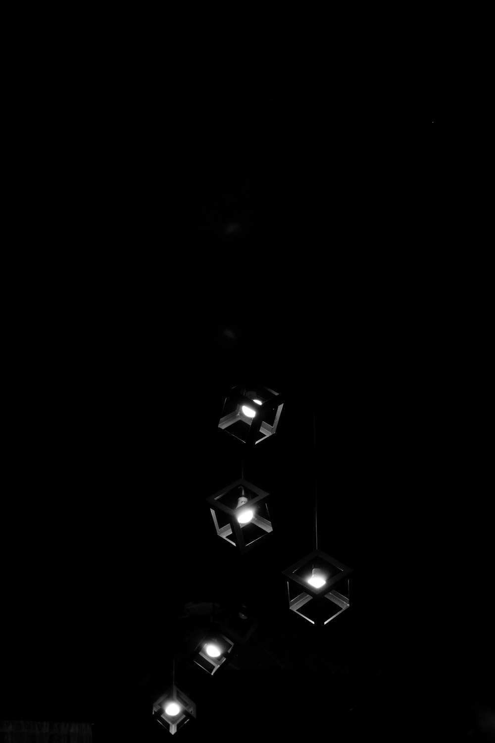 a black and white photo of four lights in the dark