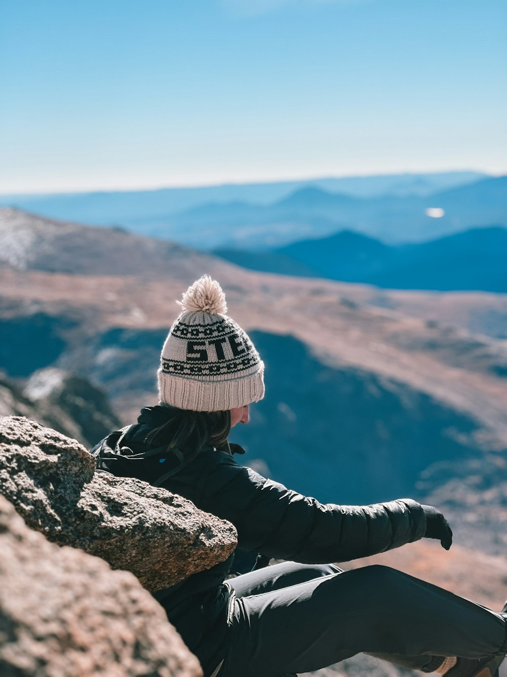 a person sitting on top of a large rock