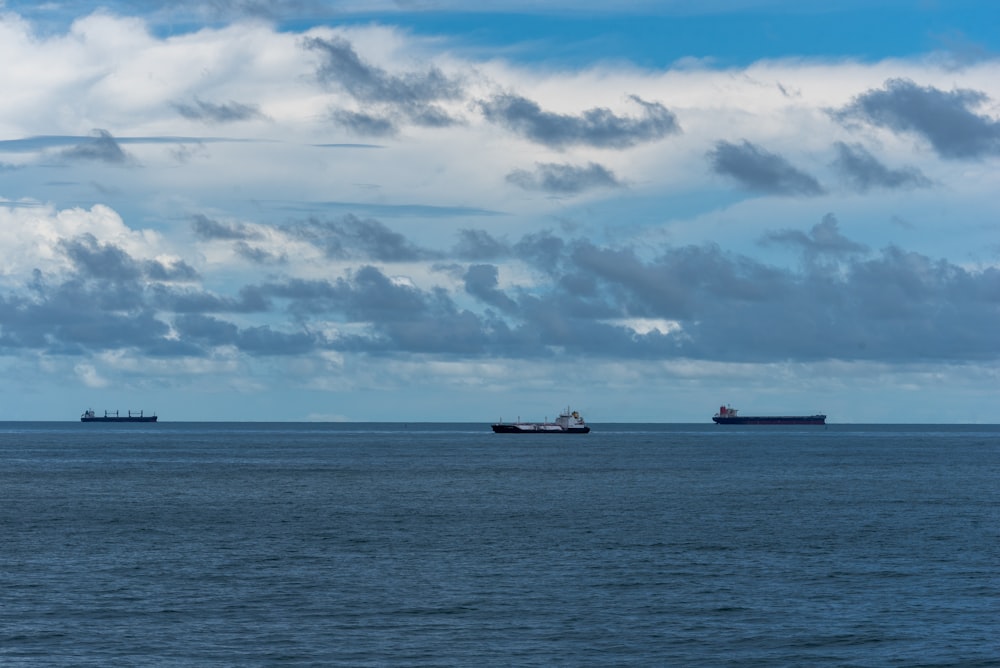 two ships in the ocean under a cloudy sky