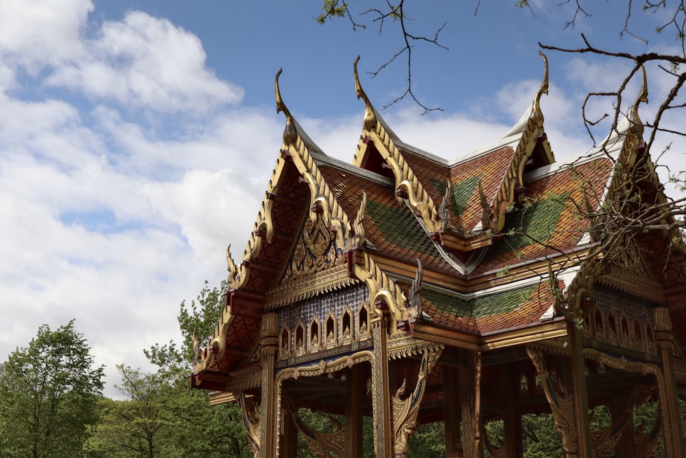 a wooden gazebo in a park with trees in the background