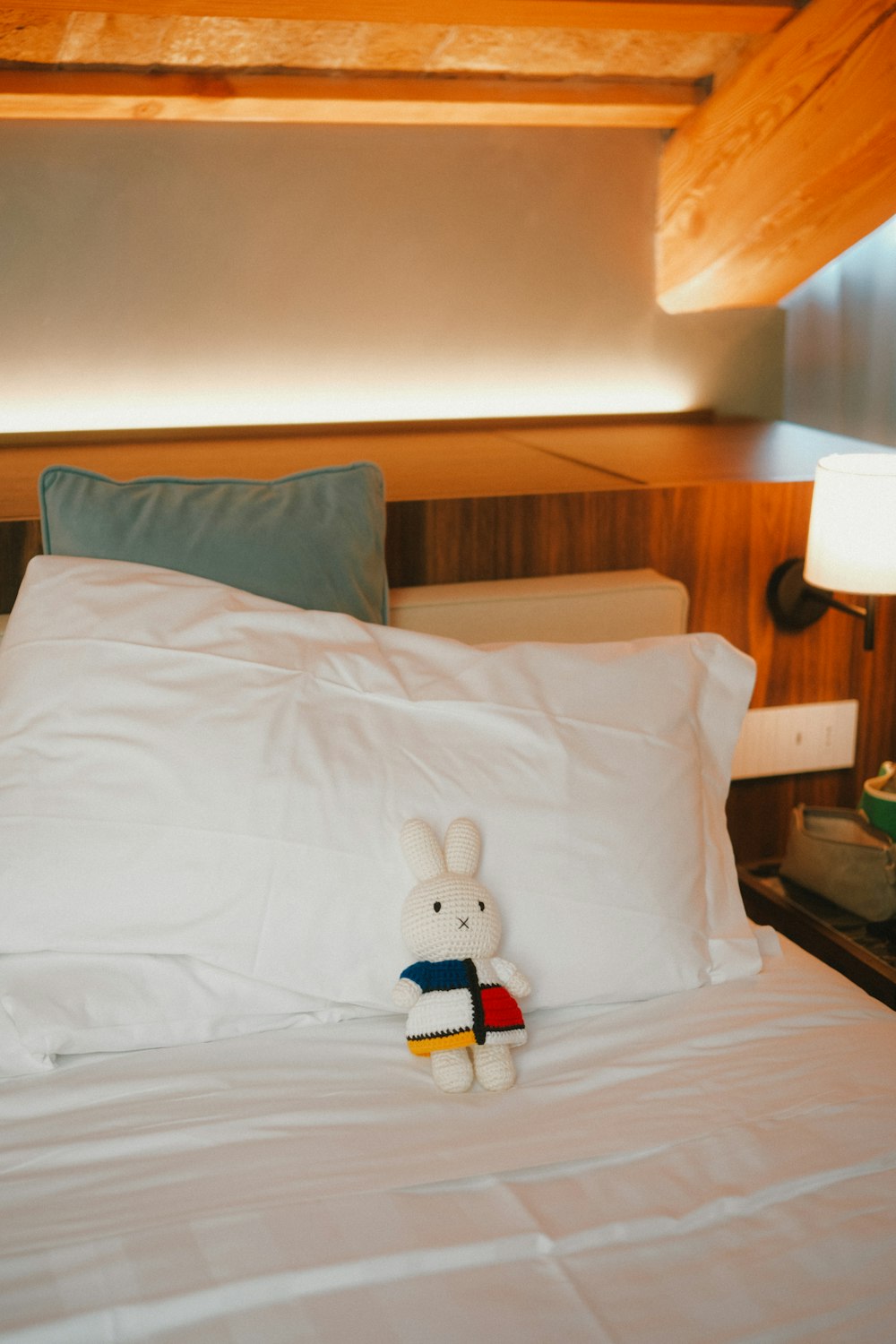 a teddy bear sitting on top of a white bed