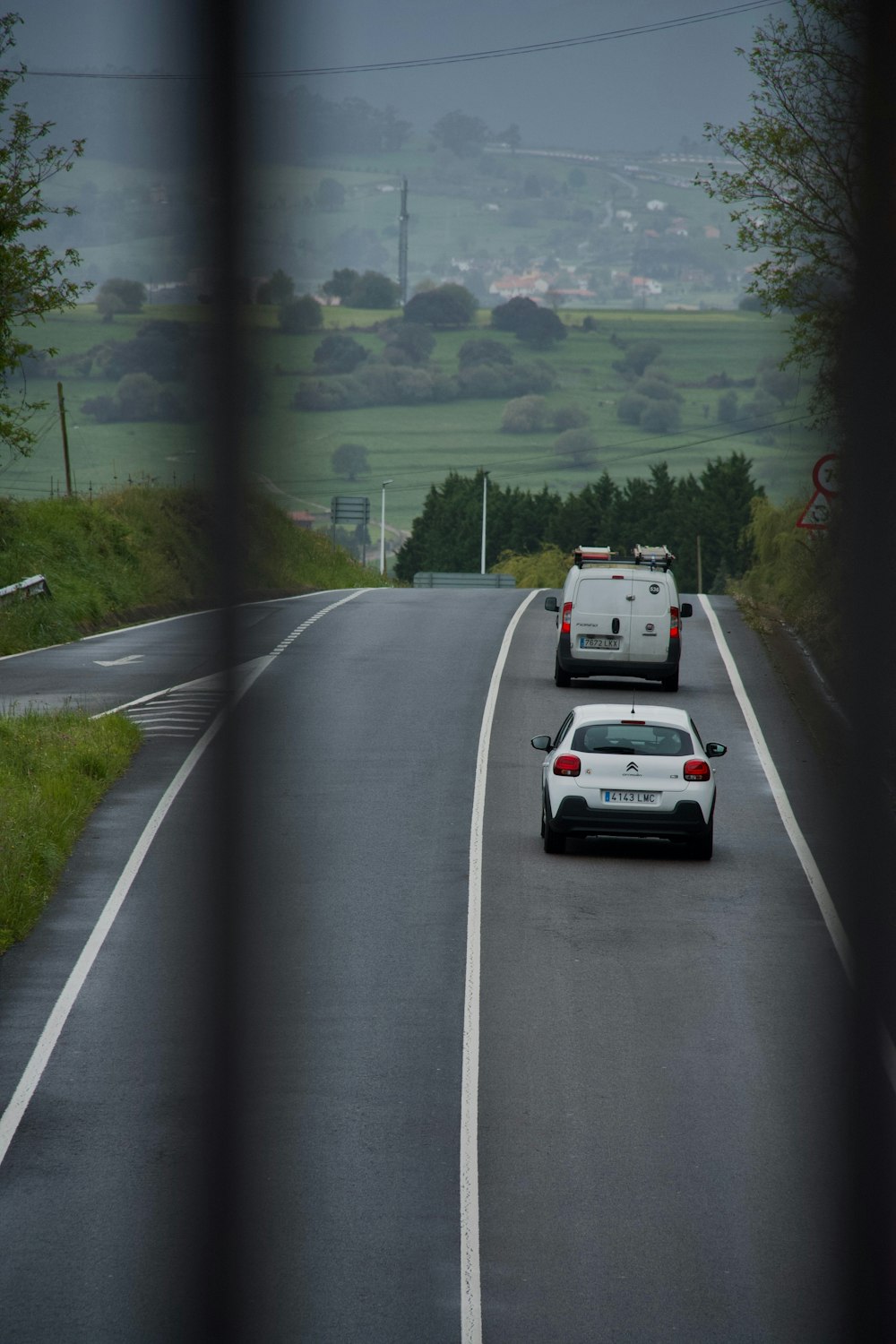 a couple of cars driving down a road