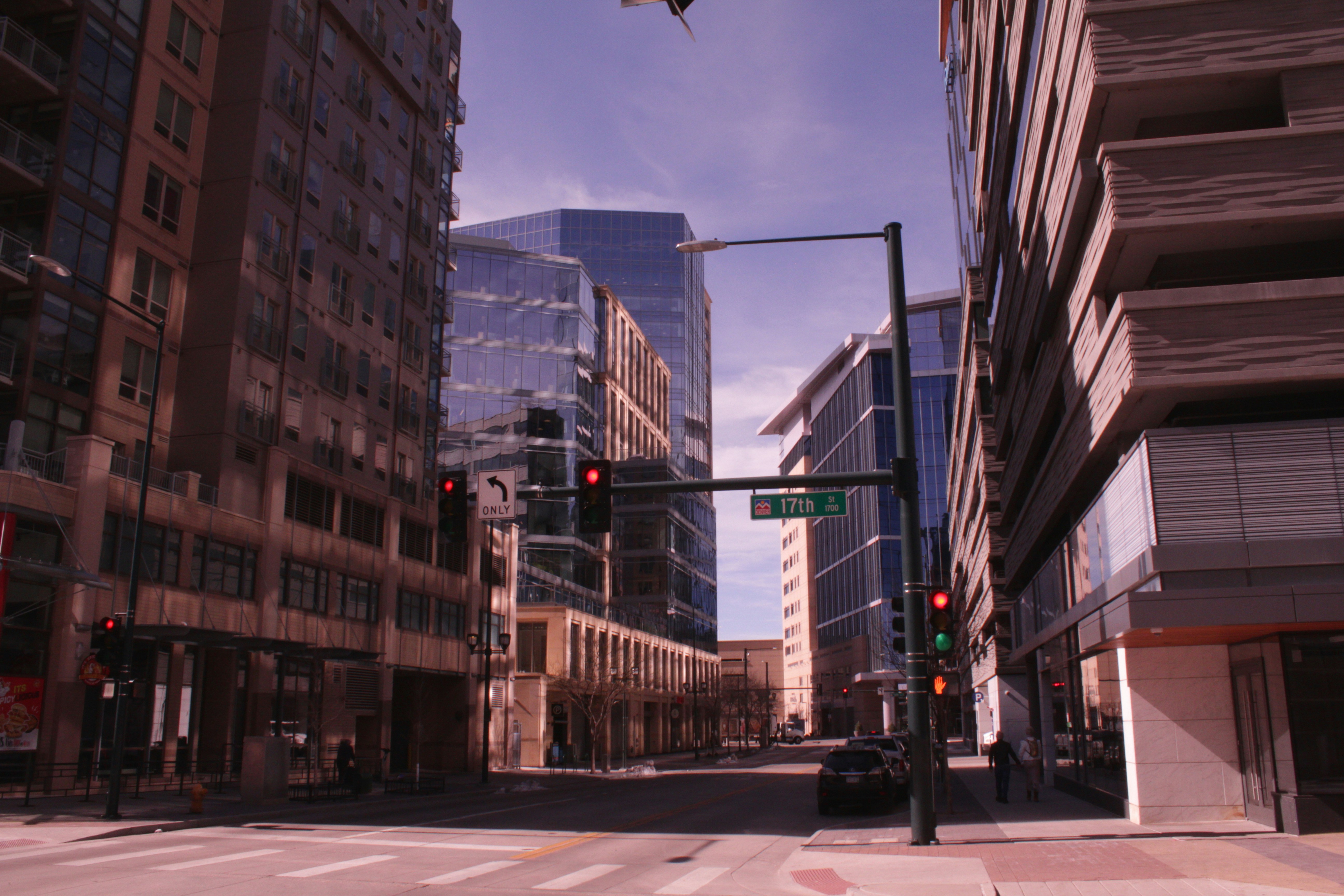 a city street with tall buildings and a traffic light, 17th Street in Denver on a morning. Removing the IR filter from the camera sensor leads to a certain magenta / red tint that reminds me of sort of a 70s aesthetic.