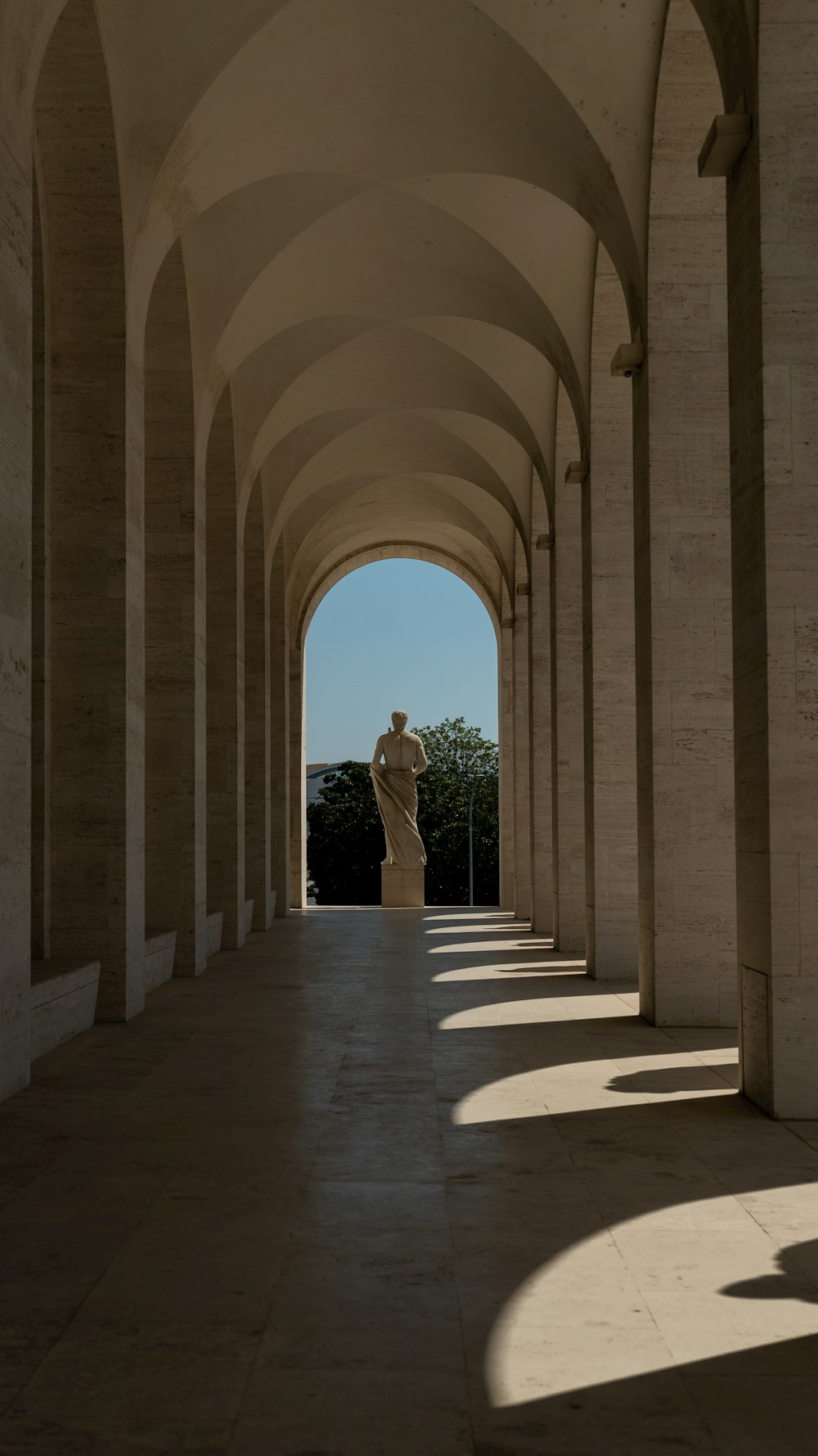 a long hallway with a statue in the middle of it