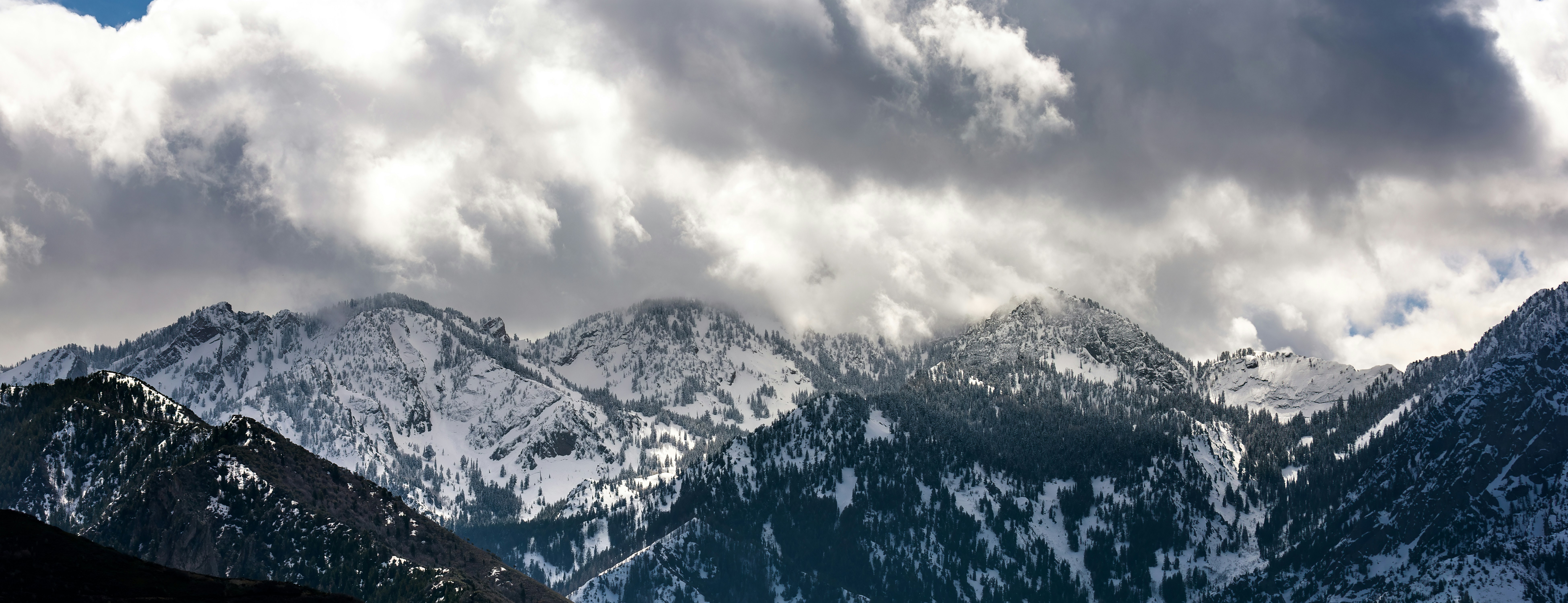 A mountain range covered in snow under a cloudy sky photo – Free Nature ...