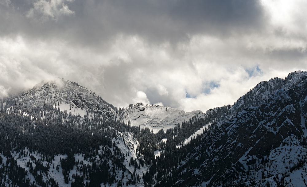 a mountain covered in snow under a cloudy sky