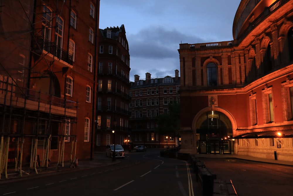 a city street at night with buildings lit up