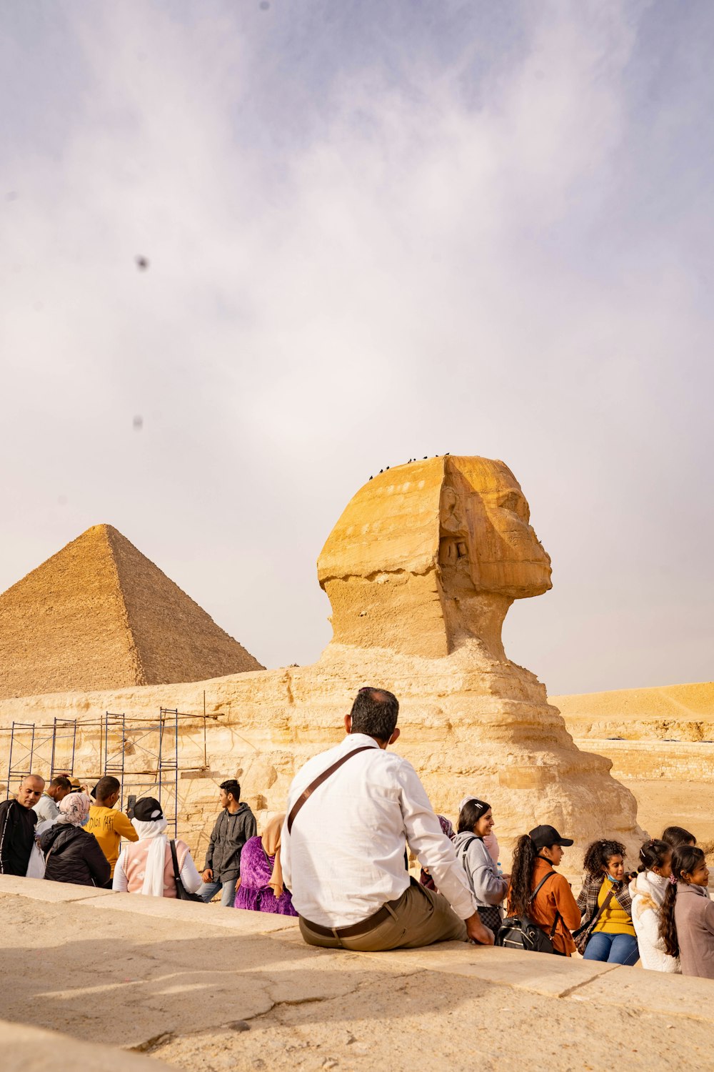 a group of people sitting in front of a large sphinx