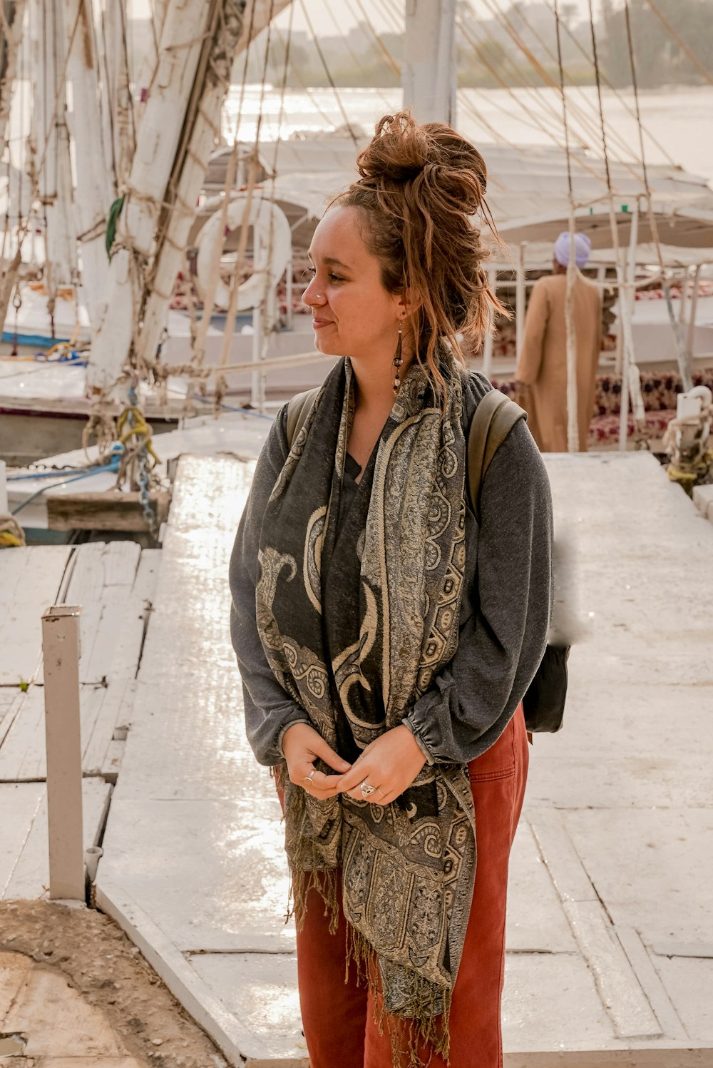 a woman standing on a dock next to a boat