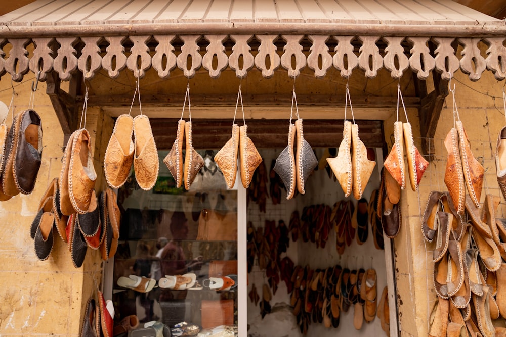 a store front with lots of hats hanging from it's windows