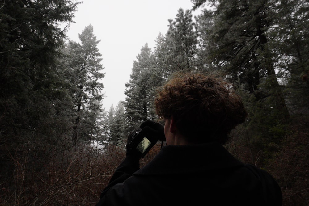 a man taking a picture of a forest