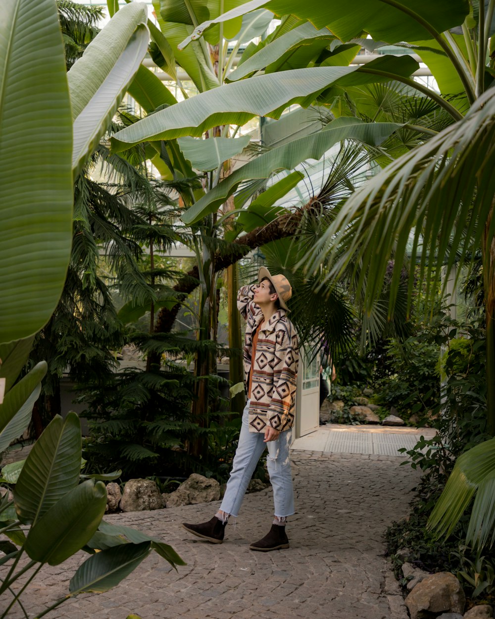 a man walking through a lush green forest