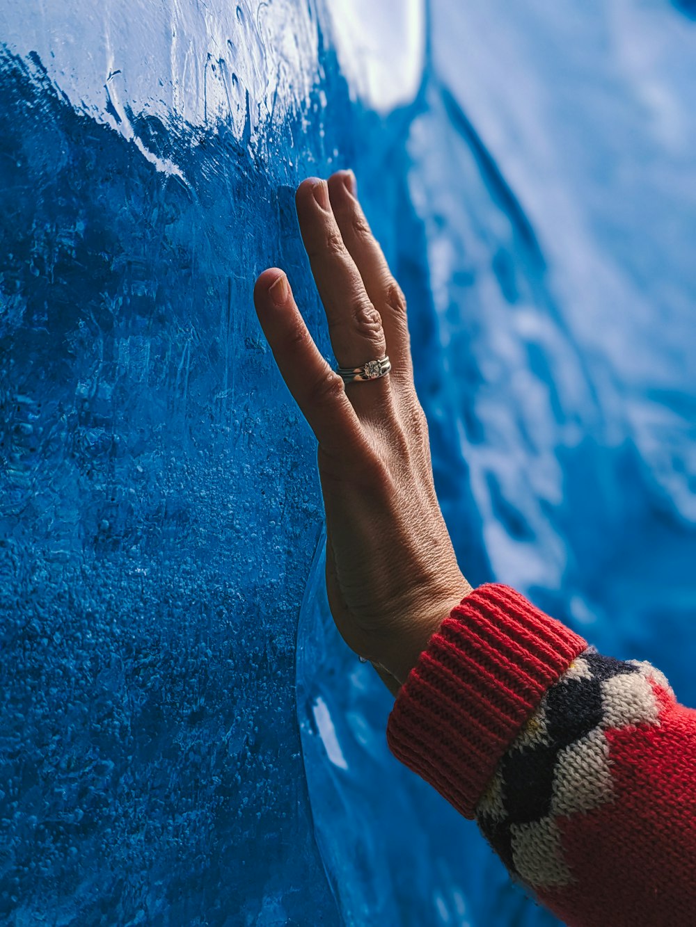 a person's hand on the side of a blue car