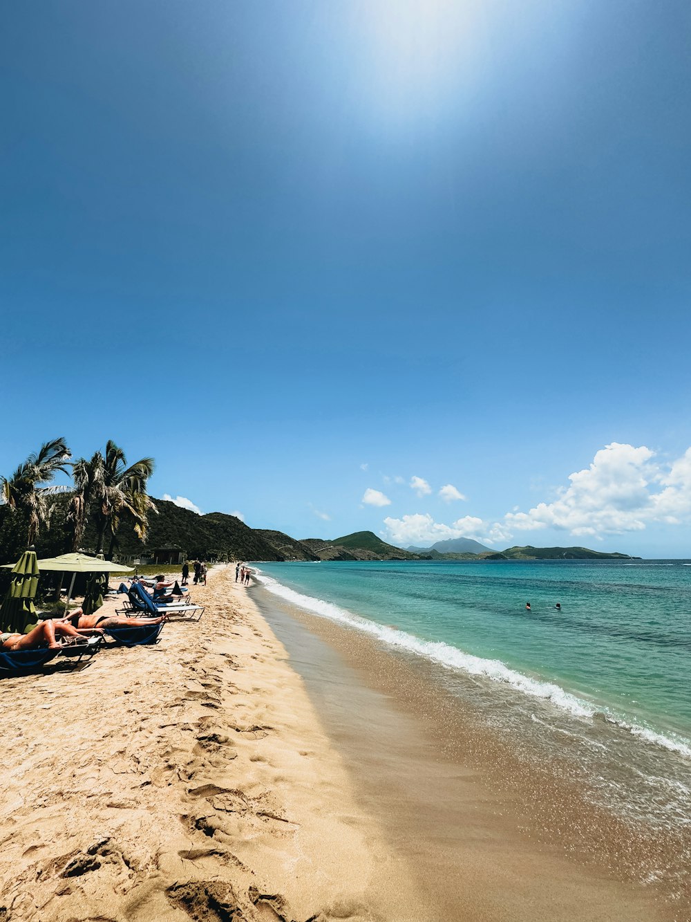 a group of people laying on top of a sandy beach