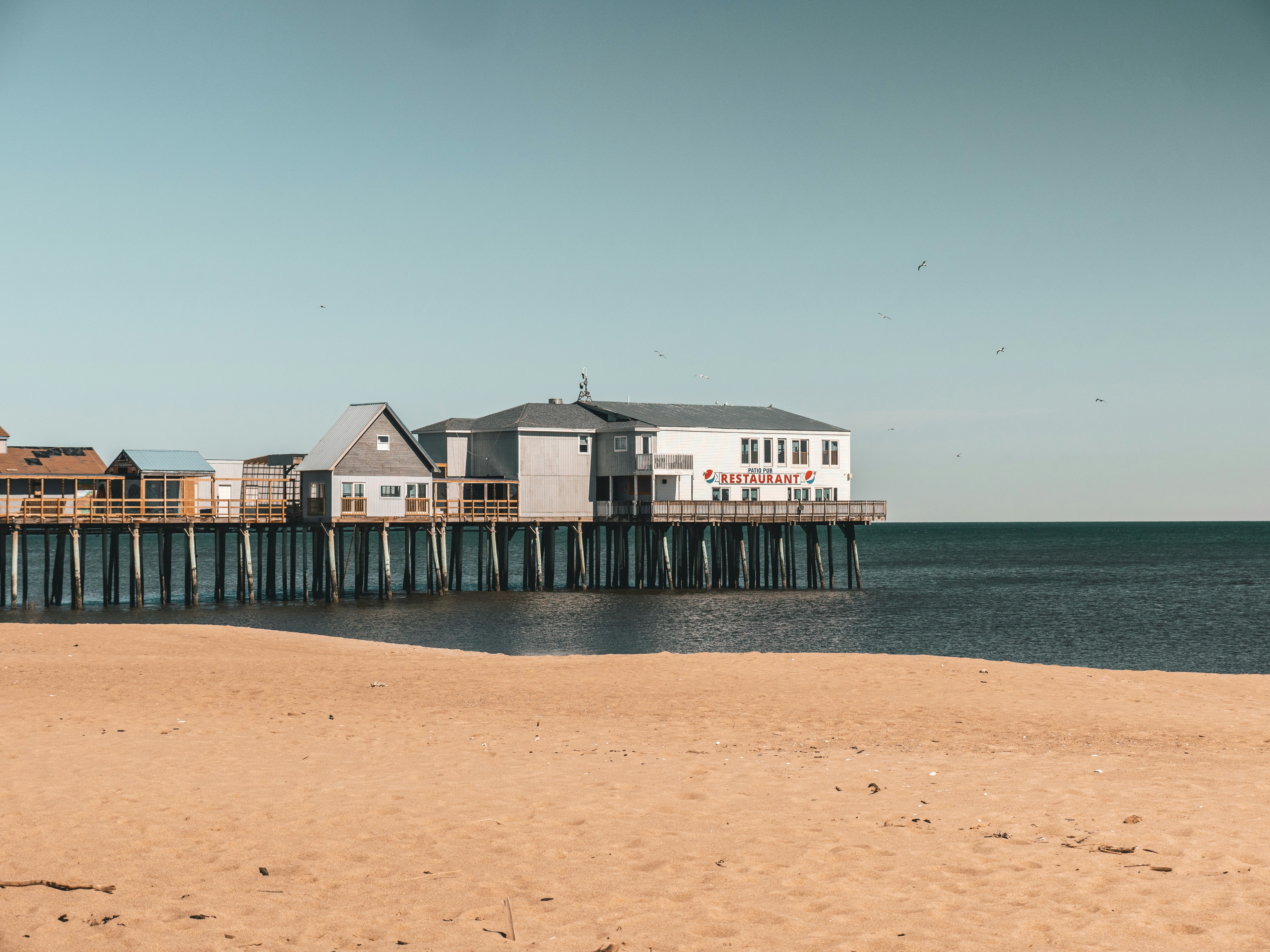 a beach with a pier and houses on it