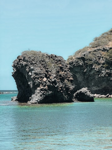 a large rock formation in the middle of a body of water