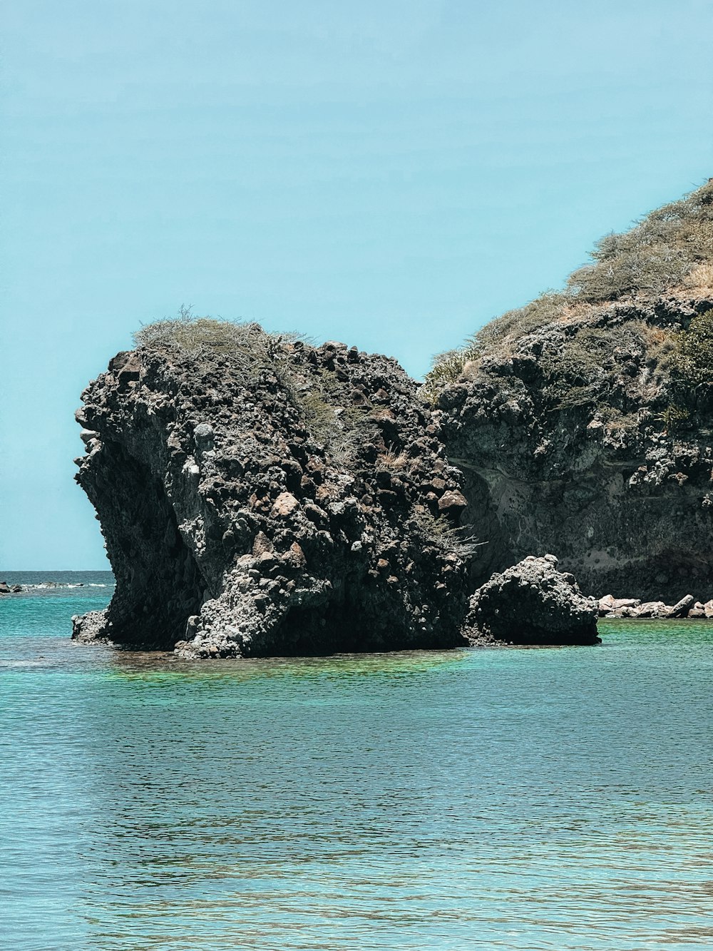 a large rock formation in the middle of a body of water