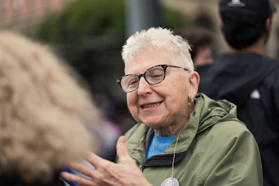 a woman with glasses talking to another woman