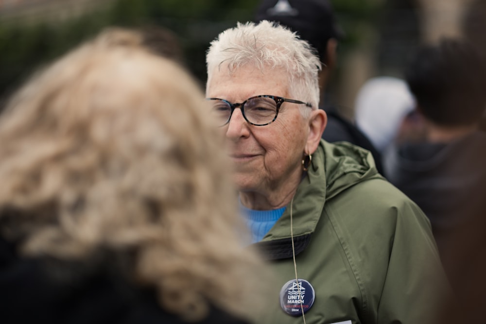 a man with white hair wearing a green jacket