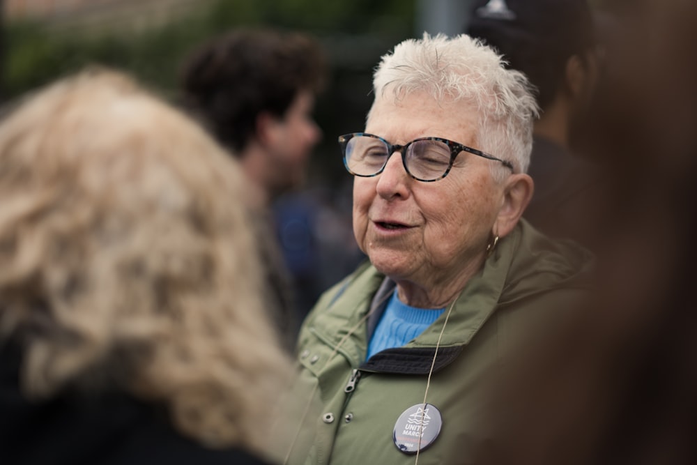 an older woman with glasses talking to a group of people