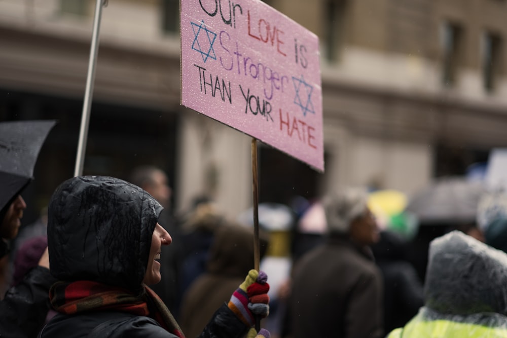 a person holding a sign that says out life is astounding as you hate