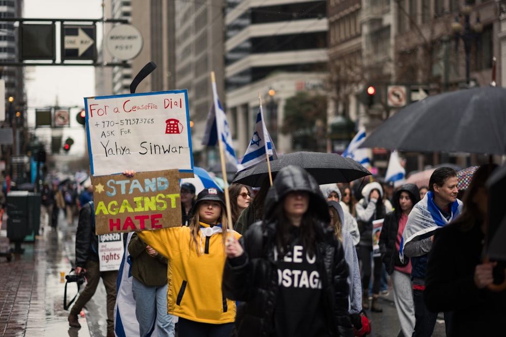 a group of people walking down a street holding signs