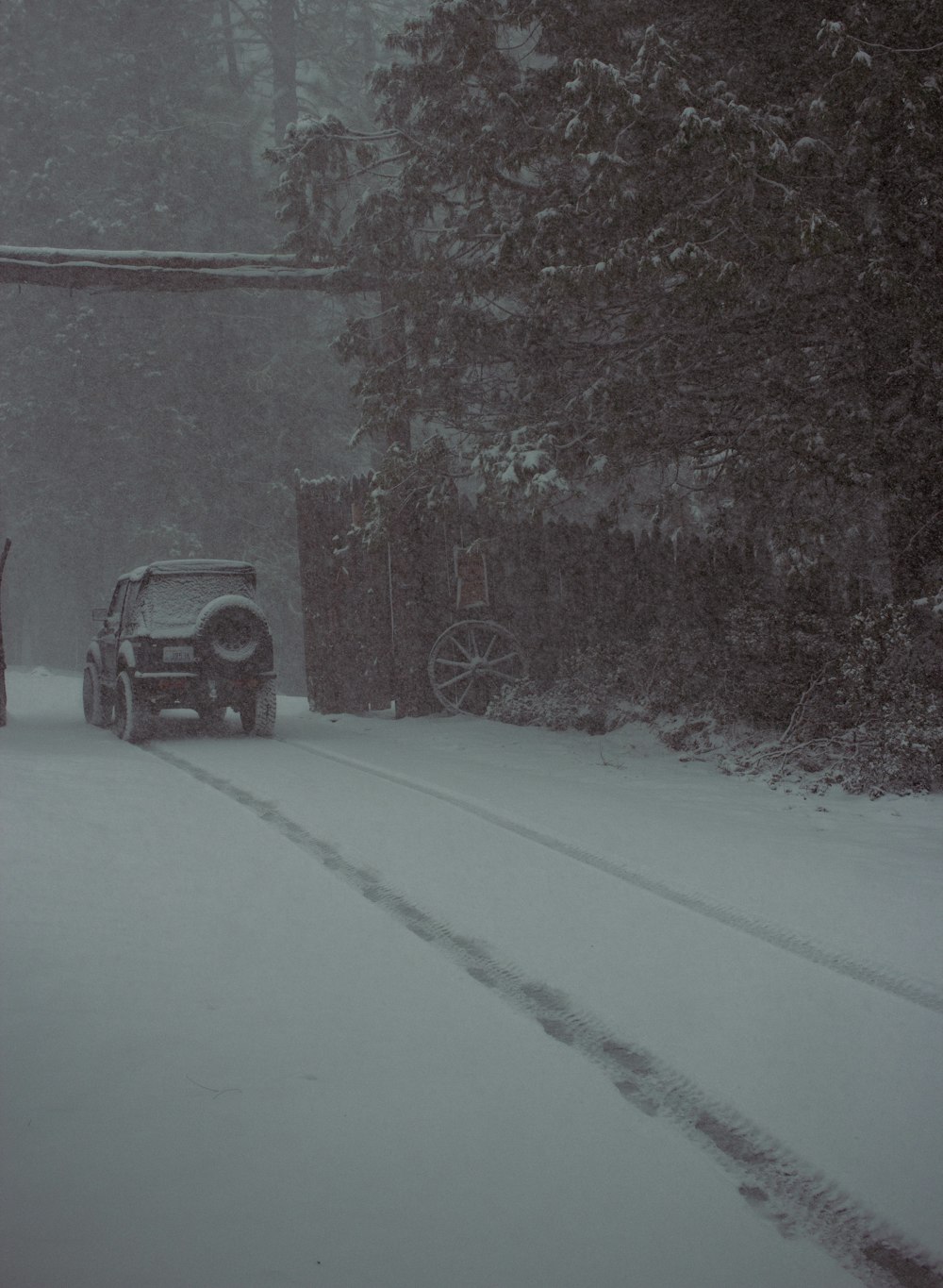 a truck driving down a snow covered road