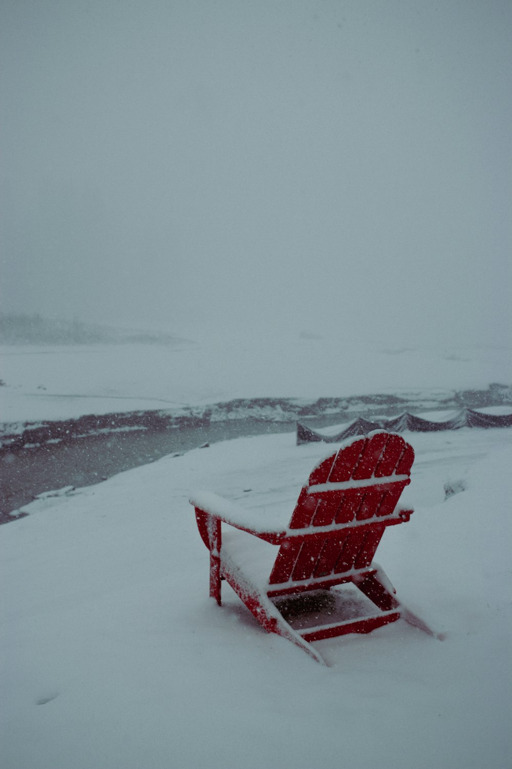 ein roter Stuhl, der auf einem schneebedeckten Feld sitzt