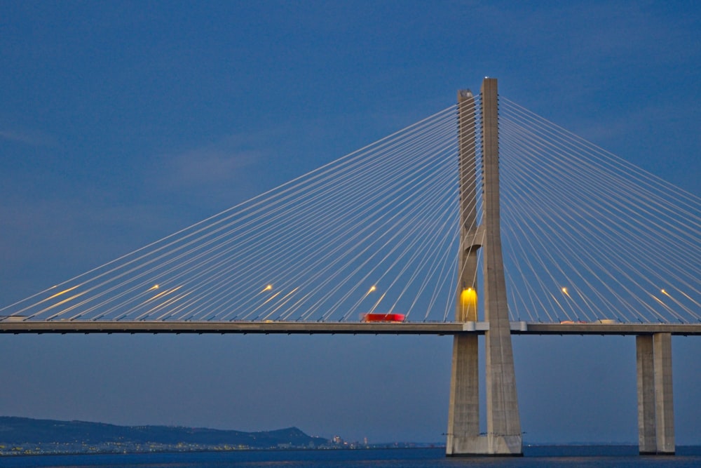 a red car is driving across a bridge