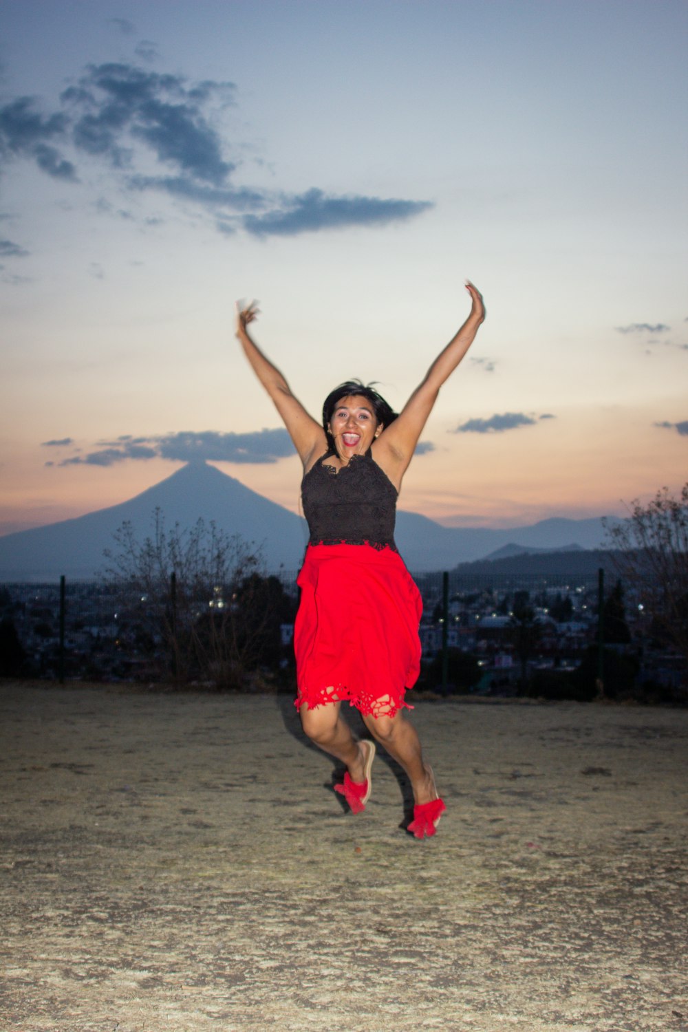 a woman in a red skirt jumping in the air