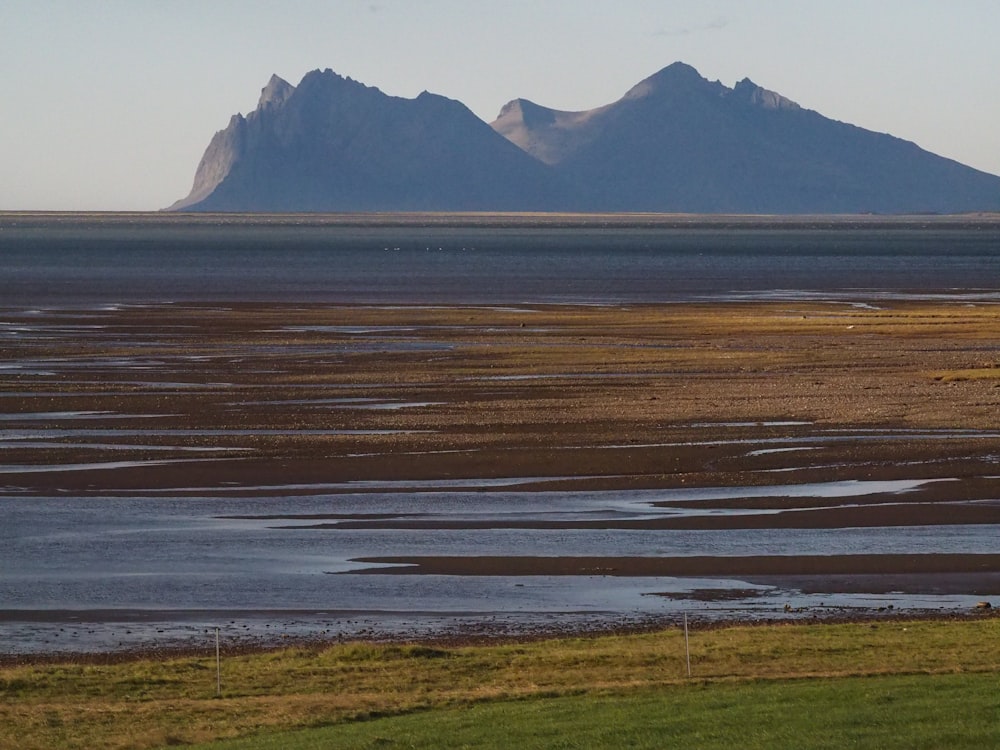 a large body of water with a mountain in the background