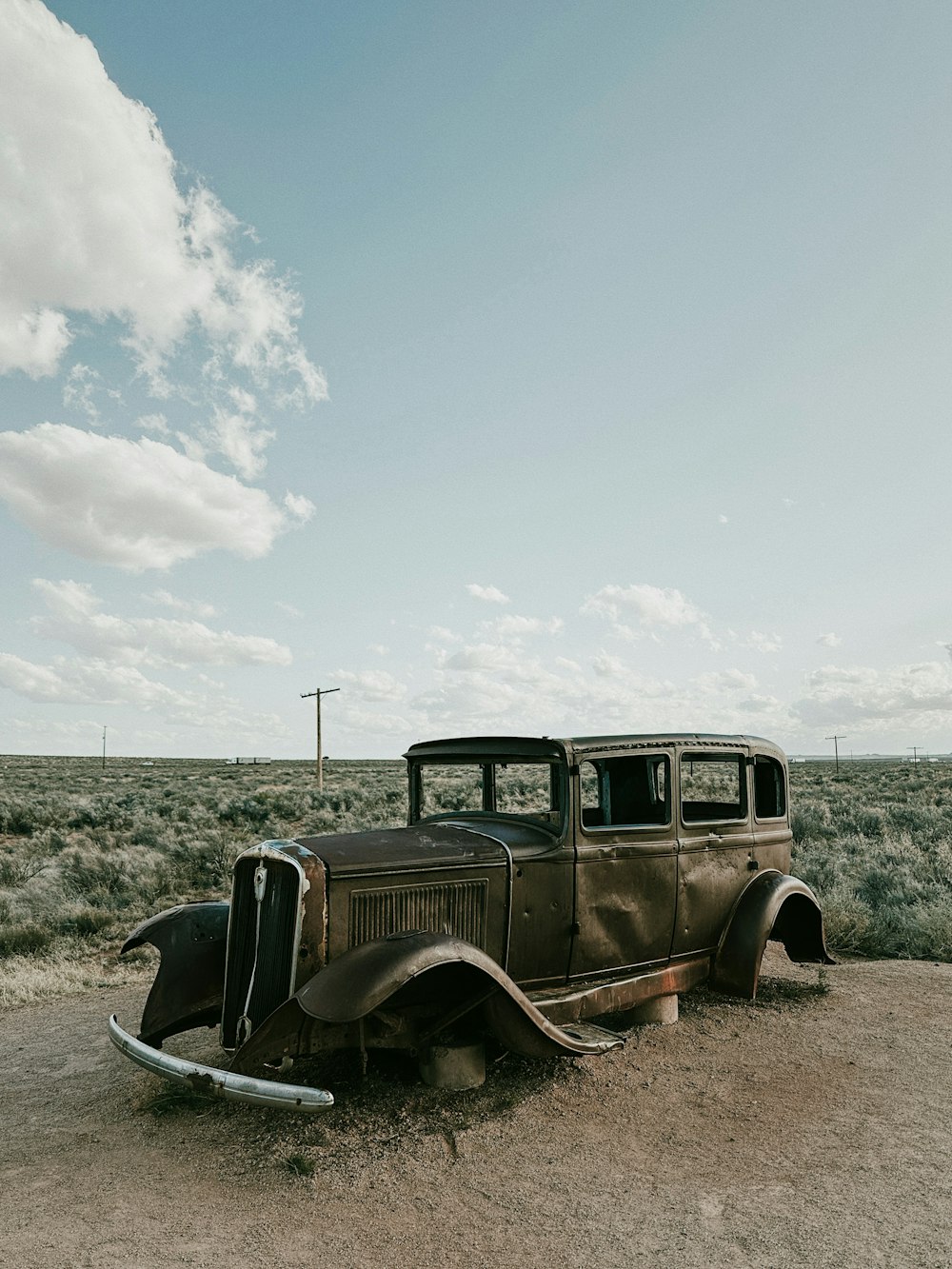an old car sitting in the middle of a field