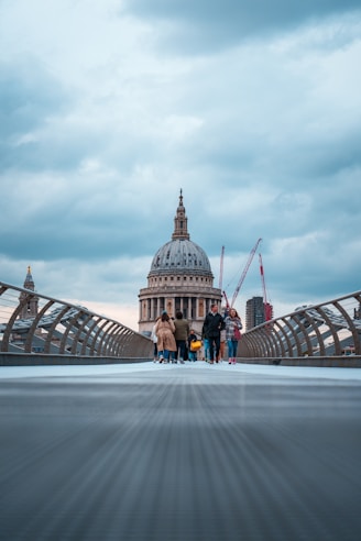 a group of people walking across a bridge